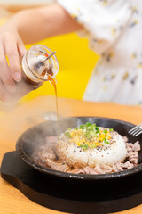 meat with rice have vegetable on top put on hot plate after cook make steam flow over, putting sauce into it