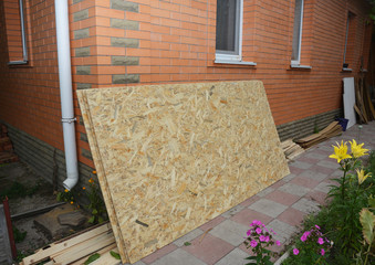 Oriented strand board (OSB) near brick house wall