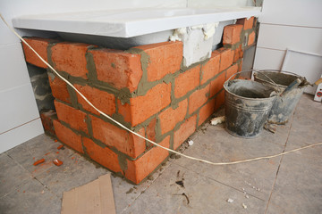 Installing bathtub.Bathtub installation with bricks in house bath room.