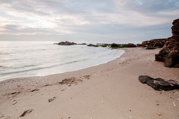 Fototapeta na wymiar Long exposure beach with fine sand and cloudy sky