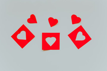 Three red paper hears  with three squares with heart pattern on the light grey background. Saint Valentine s Day concept. 