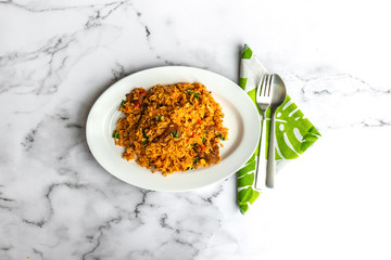 Sambal is a generic term for chili-based sauces. Fresh spices and herbs are combined to make this delicious spicy Malay dish, Sambal Fried Rice. Flay lay Asia muslim food on table.