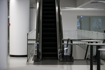 Obraz premium Escalator in Community Mall, Shopping Center. Moving up staircase. electric escalator. Close up to escalators. Close up floor platform. yellow bands. metal line steel. yellow gray steel line.