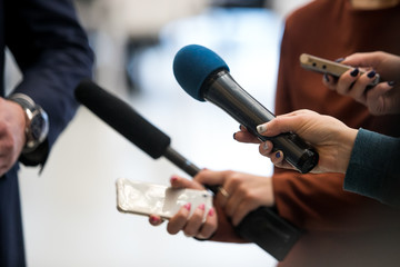 Journalist With Microphone Interviewing Businessman, politician