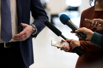 Journalist With Microphone Interviewing Businessman, politician