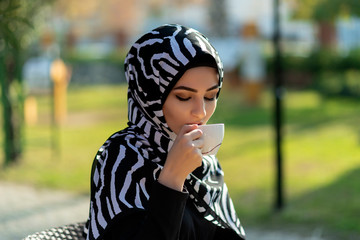 Fototapeta premium Young beautiful muslim female holding coffee cup