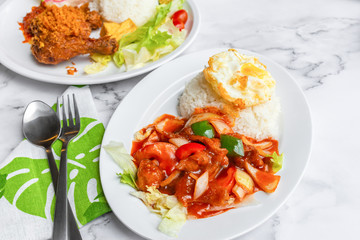 Sweet and Sour Chicken or Fish, fried egg and jasmine Thai rice. Asian food on table concept.