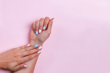 Woman's hands on pink table showing beautiful salon manicure