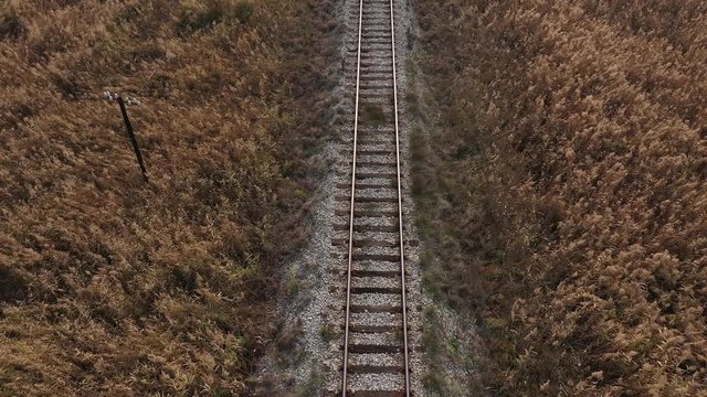 Descending on railroad line in the prairie 4K aerial video