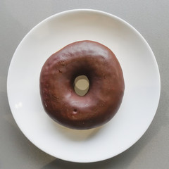 Chocolate donut on white plate