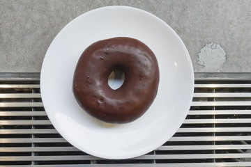 Chocolate donut on white plate