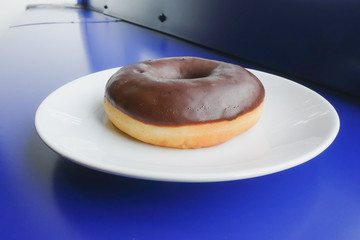 Chocolate donut on white plate