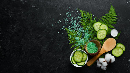 Cosmetics from green cucumber, on black stone background. The concept of cosmetics and spa. Top view. Free copy space.