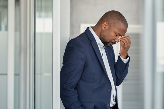 Stressed businessman with headache standing