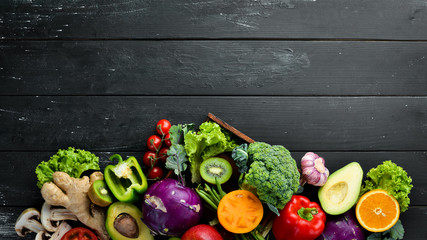 Fresh vegetables on a black background. Vegetarian food. Top view. Free space for your text.