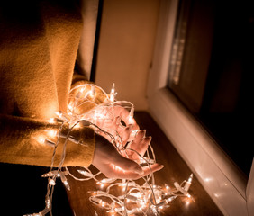 beautiful Christmas lights in the hands of a girl