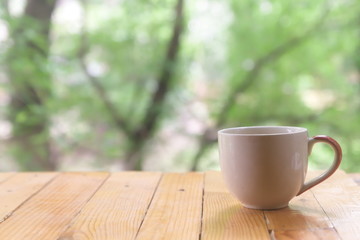  White coffee mugs set on wooden floors with a green backdrop of trees