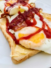Fried egg and bacon breakfast sandwich with tomato ketchup