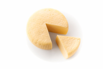 Caciotta Cheese. A triangular piece is cut out. Isolated. On white background. View from above.
