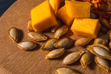  healthy pumpkin with seeds cut into slices and cubes for baking and eating. Delicious vegetarian food. Many vitamins and substances.