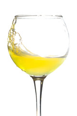 wine glass splashing yellow juice on a white background