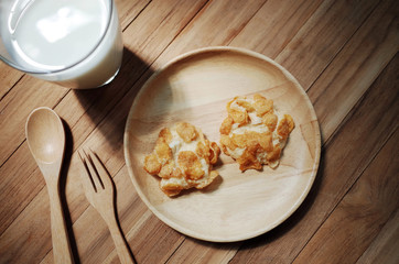 Cookies Cornflakes on wooden plate with fork and spoon with fresh milk                                                                