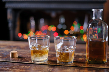 whiskey in old-fashioned glasses with ice on a wooden table