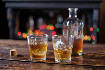 whiskey in old-fashioned glasses with ice on a wooden table