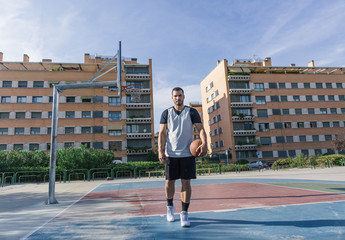 Fototapeta na wymiar Full body view of a strong urban basketball player on an outdoor court