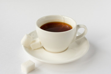 White mug with tea and sugar on a white background.