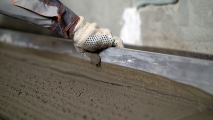 Laying floors with a solution. Pouring, laying concrete at the construction site using buckets of cement. Building, concrete work on the roof. Alignment of the concrete screed. Workers pour the soluti