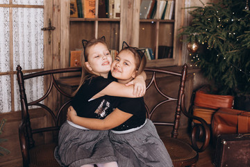 Obraz na płótnie Canvas Two cheerful adorable girls sisters in christmas decorated home. Holidays, childhood, sisterhood , friendship concept