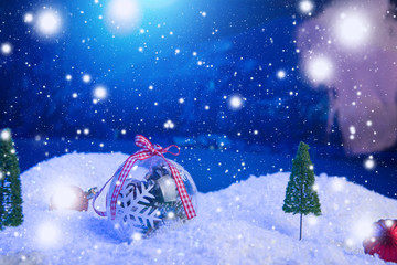 Obraz na płótnie Canvas Christmas background with Christmas balls on snow over fir-tree, night sky and moon. Shallow depth of field. Christmas background. Fairy tale. Macro. Artificial magic dreamy world.