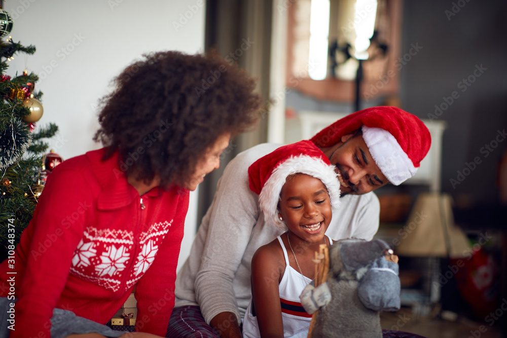 Wall mural cheerful family celebrate a Christmas holiday and  playing with girl