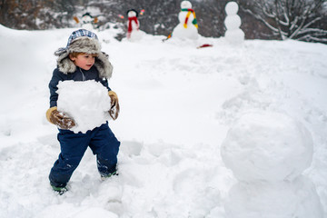 Fototapeta na wymiar Cute kid - winter portrait. Winter scene with happy child on white snow background. Winter portrait of cute child in snow Garden.