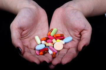 with hands cuffed and medicine pills on black background