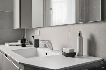 Obraz na płótnie Canvas interior shot of a modern bathroom in foreground the integrated washbasin with faucet