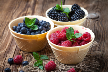Blackberries, raspberries and blueberries in a waffle bowls.