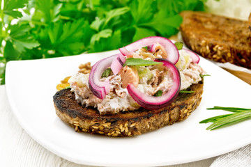 Bruschetta with fish and curd in plate on board