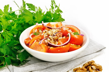 Salad with tomato and walnut in plate on board