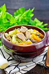 Soup Eintopf in clay bowl on wooden board