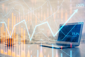 Stock market graph on background with desk and personal computer. Double exposure. Concept of financial analysis.