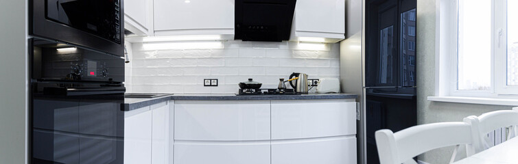 Interior of a modern white kitchen with built-in appliances. Compact minimalist kitchen.