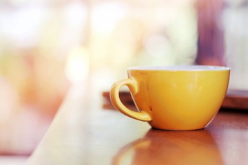 Cup of coffee on the wooden table, cozy Cafe interior background