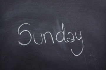 Day of the week written on a blackboard with white chalk, sunday