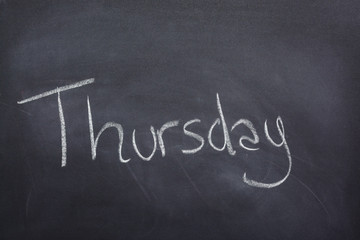 Day of the week written on a blackboard with white chalk, thursday
