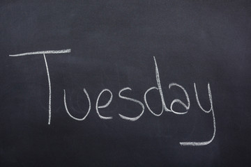 Day of the week written on a blackboard with white chalk, tuesday