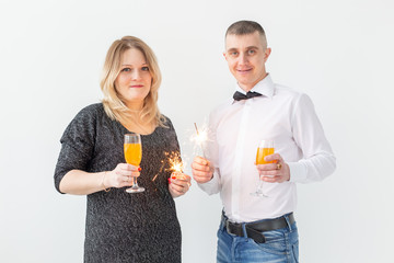 Fototapeta premium Holidays, christmas, valentine's day and new year concept - Woman and man celebrate and holds wine in a glass over white background