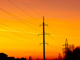Electric pole with wires on a sunset background