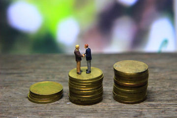 Simple Illustration Photo Successfull Bussiness Transaction, Two Man Handshaking at golden indonesia 500 Rupiah Coin, Green Forest as a background